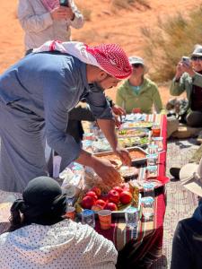 瓦迪拉姆bedouin future camp的站在桌子上一边吃着食物的女人