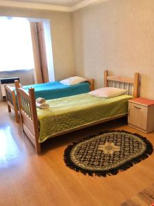 第比利斯1 Bedroom Apartment的卧室配有两张床,地板上铺有地毯。