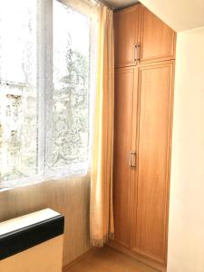 第比利斯1 Bedroom Apartment的厨房配有木制橱柜和窗户。