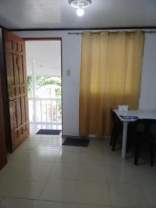 DaanbantayanMatterhorn Guest House的一间设有桌子和滑动玻璃门的房间