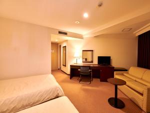 长野Hotel Courtland的配有一张床和一张书桌的酒店客房