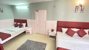 马拉里Hotel Meadows View, Near Mall Road Manali的客房配有两张带红白色枕头的床。