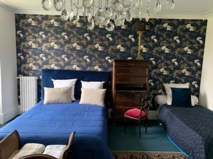 Ris-OrangisDomaine de Ris的一间卧室配有蓝色的床、梳妆台和椅子