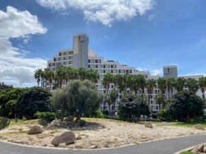 法纳贝海滩Adeje Beach Holiday Home Viña del Mar的一座白色的大建筑,前面有棕榈树