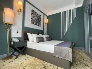 巴库Teatro Rooms Hotel的一间卧室设有一张带绿色墙壁的大床