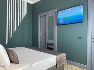 巴库Teatro Rooms Hotel的卧室配有一张壁挂式平面电视的床。