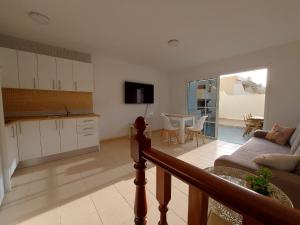 卡勒达德福斯特We Fuerteventura的厨房以及带沙发和桌子的客厅。