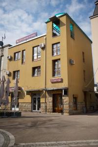 弗尔尼亚奇卡矿泉镇帕森斯格公寓式酒店的一座黄色的大建筑,有一座建筑