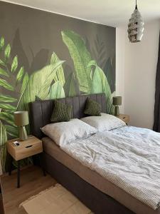 扎马迪Zamárdi Margittai Apartmanok的一间卧室配有一张带叶子壁画的床