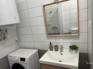 扎马迪Zamárdi Margittai Apartmanok的白色的浴室设有水槽和镜子
