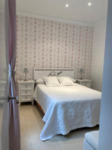 拉拉古纳Los Roques的卧室配有白色的床和2个床头柜