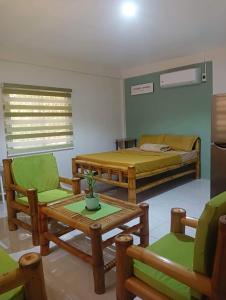 BolinaoMichaels Homestay - Farm Villa nr Patar Beach & Bolinao Falls的配有一张床和一张桌子及椅子的房间