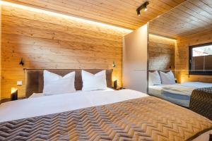 施尔奇Bergwaldchalet Komfort的卧室设有白色大床和木墙