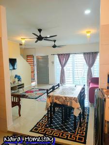 哥打巴鲁Naira Homestay Kota Bharu ,Wakaf Che Yeh 4 Bilik 3 Aircond的客厅配有桌子和吊扇