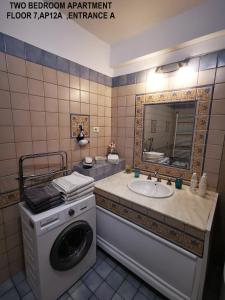 布加勒斯特Black and White Apartments的一间带洗衣机和水槽的浴室