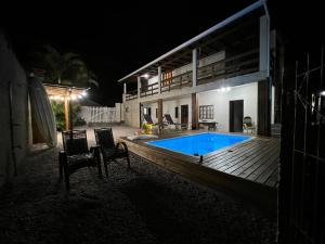 帕罗卡Recanto Pé na Areia SC的一座晚上设有游泳池的房子