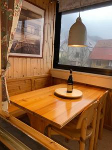 PlužnaLuxurious Townhouse Petelin的客房内的木桌旁摆放着一瓶葡萄酒
