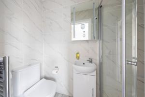 伦敦Garden View Standard Double 5Min Walk To Tufnell Park的白色的浴室设有卫生间和水槽。