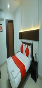 ManjeriRedbell Suites Manjeri的一间卧室配有红色和白色枕头的床