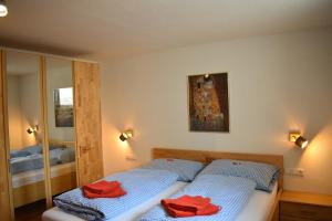 贝旺Aparthotels Berwang / Haus Wiesengrund的一间卧室配有两张带红色毛巾的床。