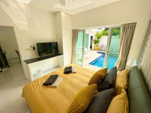 乔木提恩海滩View Talay Villas, luxury private pool villa, 500m from Jomtien beach - 45的一间卧室配有一张床、一张沙发和一台电视。