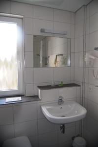蒂宾根拜德酒店的白色的浴室设有水槽和窗户。