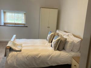 Grizebeck2 Malt Kiln Cottages的卧室配有白色的床和枕头。