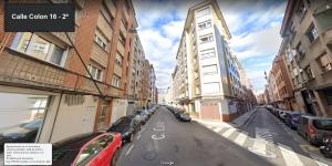 希洪Apartamento de Colón的一条城市街道,有停车的汽车和建筑