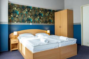 布达佩斯Gartner Hotel的一间卧室配有带白色床单和枕头的床。