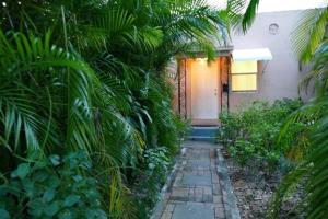 迈阿密1BR Historic Art Deco Charm Meets Modern Comfort- Huge Tropical Garden in Posh Coral Gables-10 min Airport的通往前门的走道房子