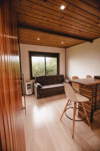 加罗帕巴Pousada Colina Verde的客厅配有沙发和桌椅