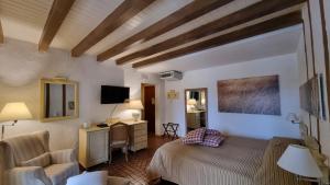San Vero Milis伊斯贝那司乡村酒店的一间卧室配有一张床、一张桌子和一把椅子