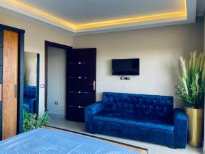 阿莱曼Porto marina chalet and apartment的客厅配有蓝色的沙发和电视