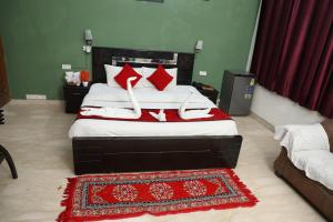 诺伊达Ashray House Noida的一间卧室配有红色和白色枕头的床