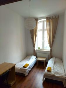 肯琴Apartament Parkowy的配有书桌和窗户的客房内的两张床