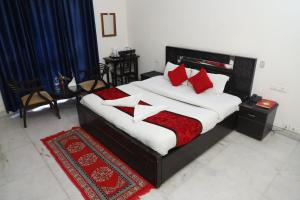 诺伊达Ashray House Noida的一间卧室配有红色和白色枕头的床