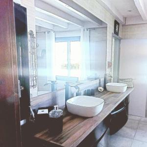 居让梅斯特拉VILLA Zaphira的一间带两个盥洗盆和大镜子的浴室