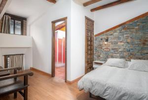 马尔帕尔蒂达德普拉森西亚Apartamentos La Solana de Monfragüe的一间卧室设有一张床和砖墙