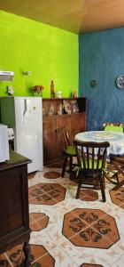 海岸城Casa en Ciudad de la Costa ideal para descanso的厨房配有桌子和绿色的墙壁