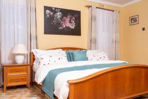 纳库鲁Augustine Cosy Homes的卧室配有带枕头的木床和窗户。
