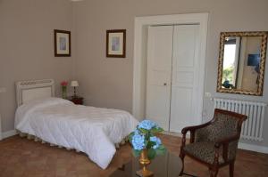 马斯卡卢恰Le stanze dei Mori - quadrupla con bagno privato的一间卧室配有一张床、一把椅子和镜子