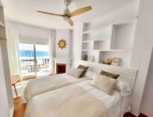 托雷德尔马尔Caleta Beach House Villa Beatriz Sinese Design的一间卧室配有两张床和吊扇