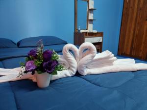 清莱หอพักโชคอนันต์的床上有两条天鹅绒毛巾和花瓶