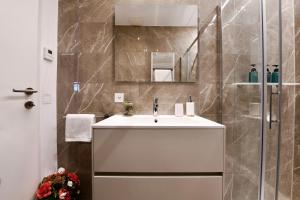 卢加诺Lake Modern Suites - Free Parking的白色的浴室设有水槽和镜子