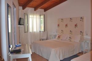 圣安蒂奥科B&B La Jacaranda affittacamere的卧室配有白色的床和窗户。