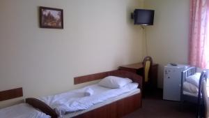 GrabowiecHostel Miłosz的酒店客房设有两张床和电视。