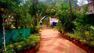 瓦加托Stan-Inn, North Goa, Vagator, with strong WIFI,free private parking & kitchen, Can Cook where you stay的花园设有种有植物的步道和围栏