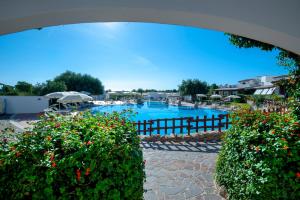 卡拉古诺内Hotel Resort Nuraghe Arvu的一座带鲜花的度假村游泳池