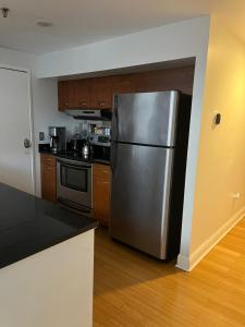 纽黑文Full loft apartment near Omni Hotel的厨房配有不锈钢冰箱和木制橱柜