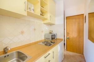 奥米沙利Apartman 3的厨房配有水槽和微波炉